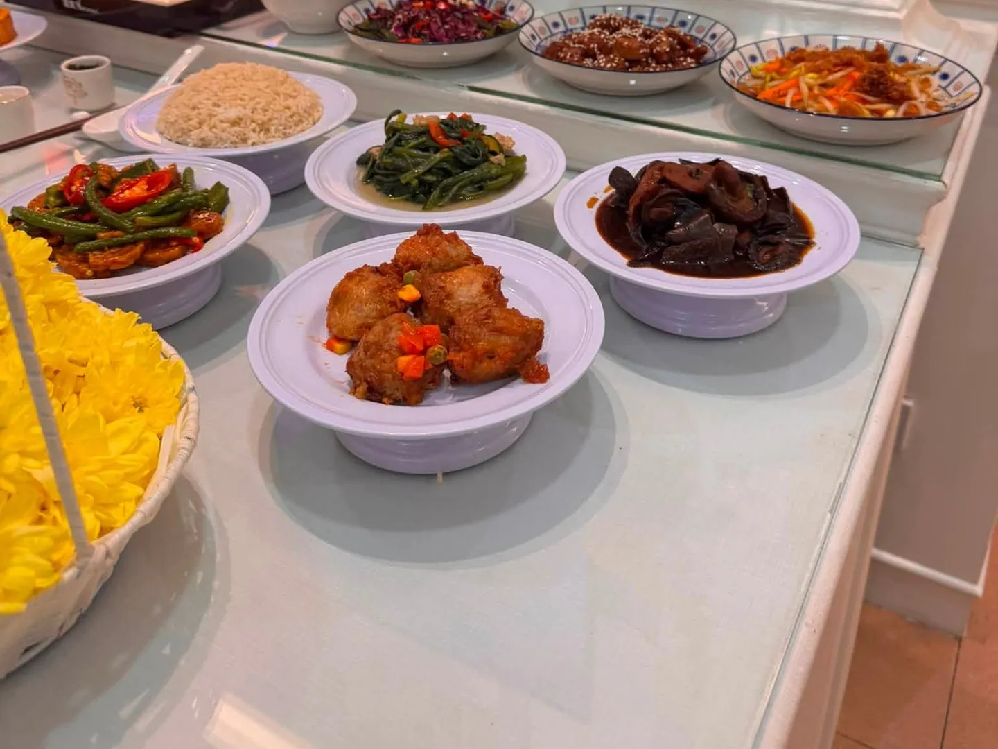 灵堂供桌上一碗碗饭菜，左边一篮黄菊花
